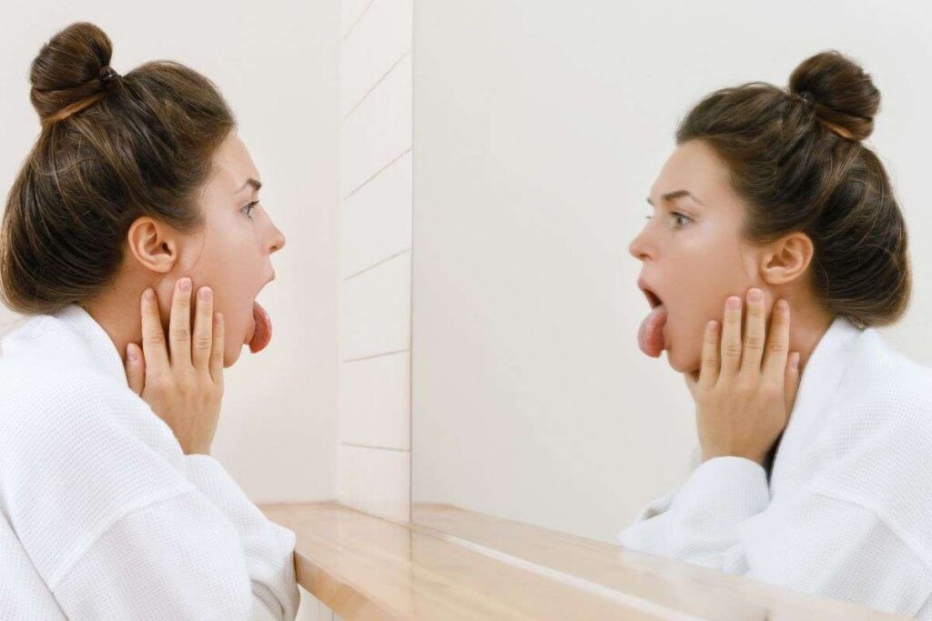 Ragazza si guarda la lingua allo specchio