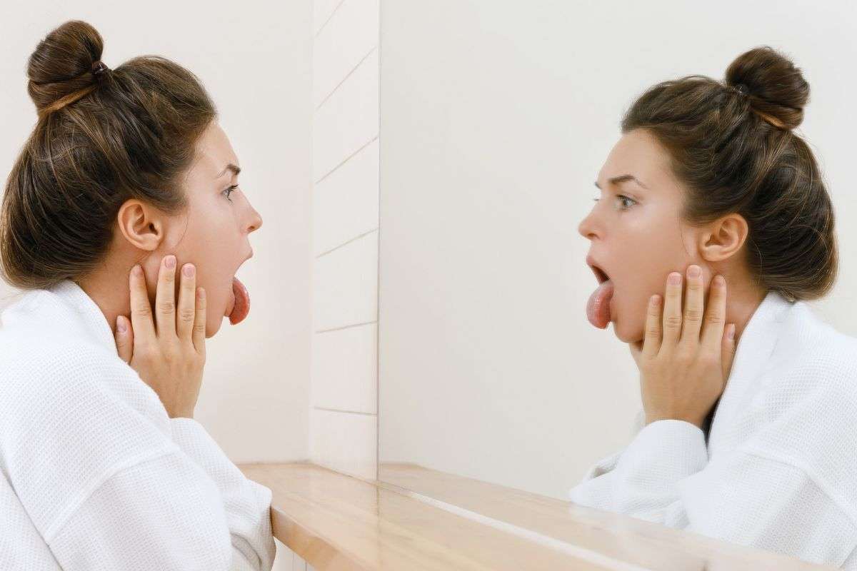 Ragazza si guarda la lingua allo specchio
