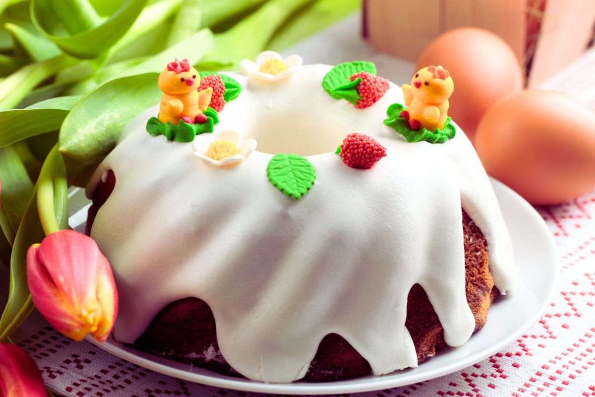 casatiello dolce con decorazioni pasquali e un mazzo di tulipani