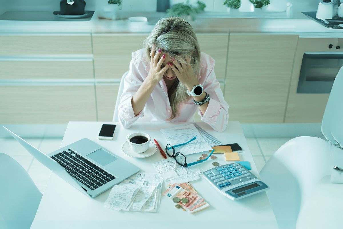 donna preoccupata per i soldi, sulla scrivania computer, denaro, calcolatrice