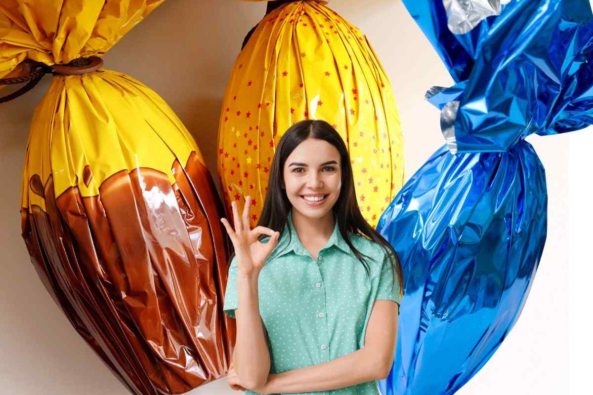 donna che fa ok con la mano, dietro uova di pasqua confezionate con carta colorata