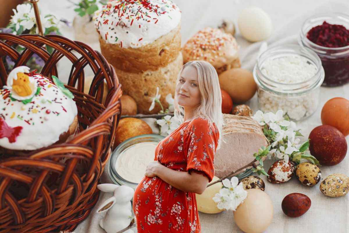 sullo sfondo alimenti di pasqua, in primo piano donna incinta