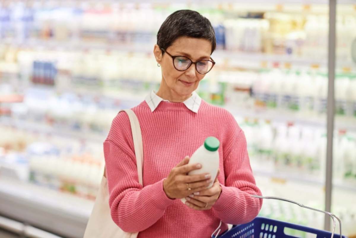Donna che controlla l'etichetta del latte