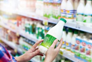 Donna con latte al supermercato