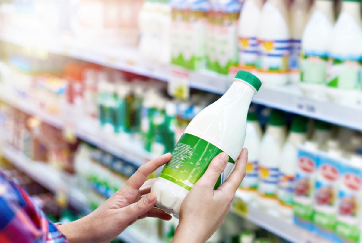 Donna con latte al supermercato