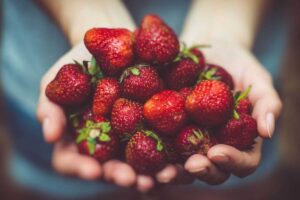 donna con delle fragole tra le mani