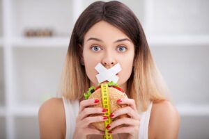 ragazza che si tiene in forma evitando di mangiare un hamburger