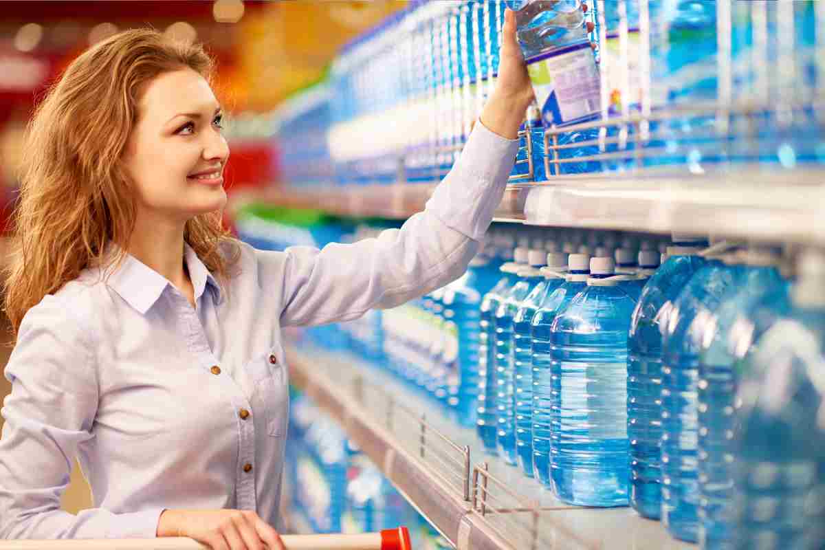 donna acquista l'acqua al supermercato
