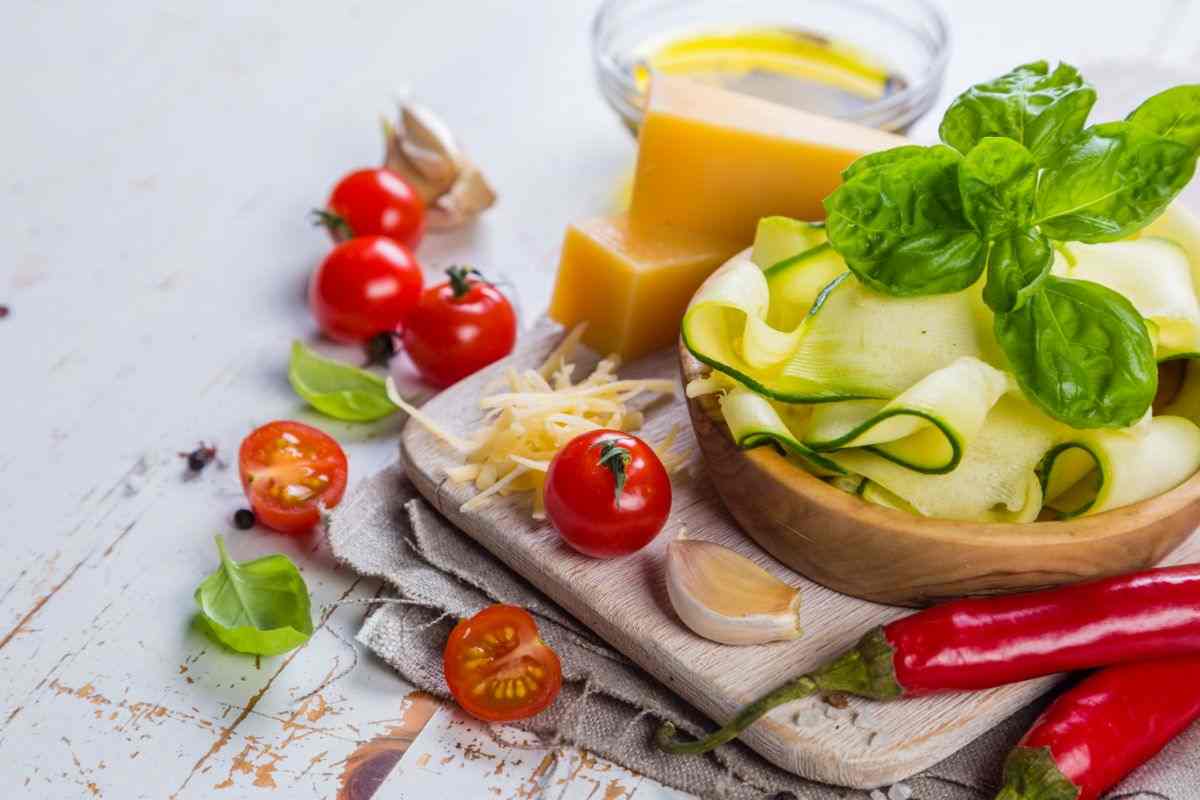 ingredienti sulla tavola: zucchine, pomodorini, formaggio