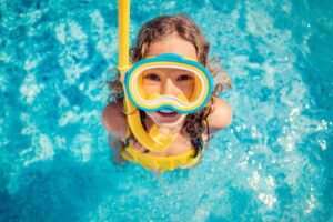 bambino in piscina con maschera