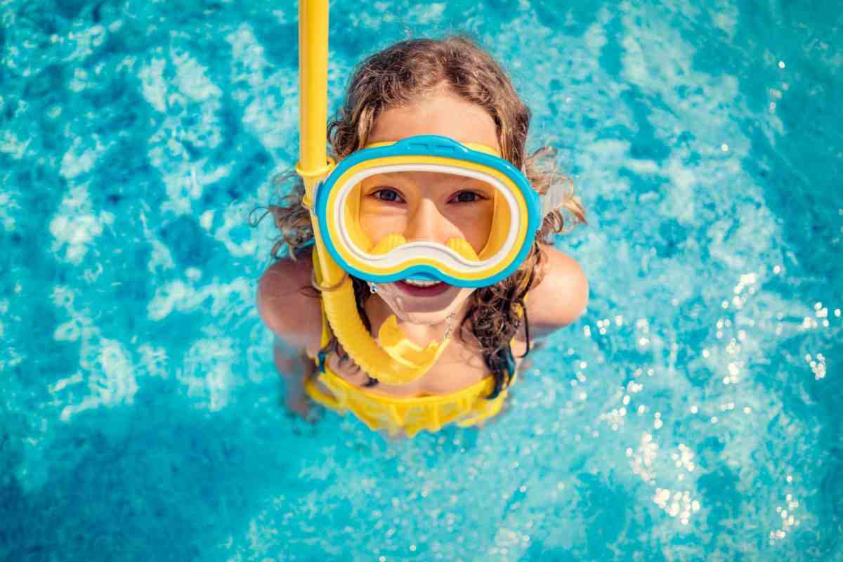 bambino in piscina con maschera