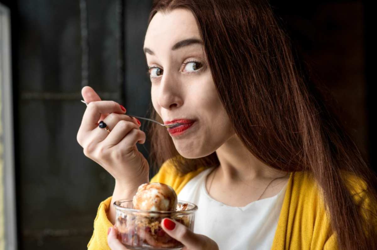 Donna mangia il gelato nella coppetta