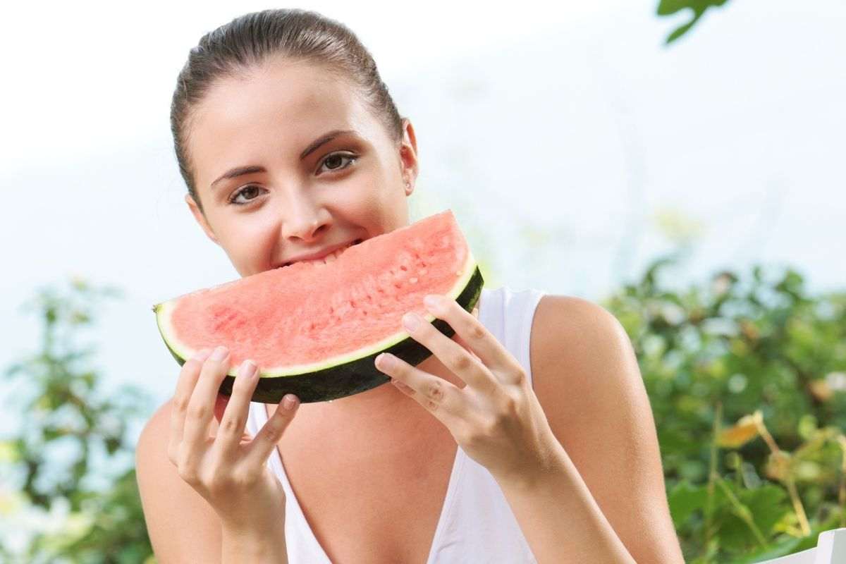 Ragazza morde fetta di cocomero