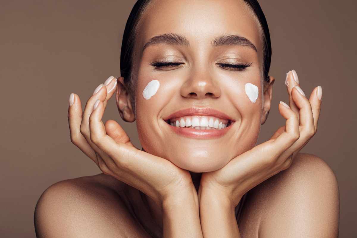 ragazza applica crema viso