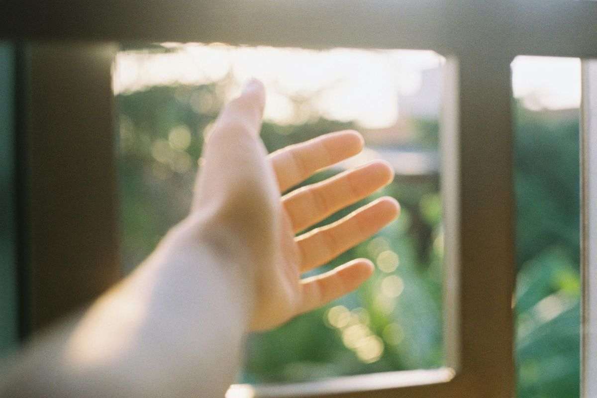 mano finestra e luce del sole