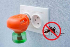 Un diffusore antizanzare attaccato alla presa elettrica ed una zanzara
