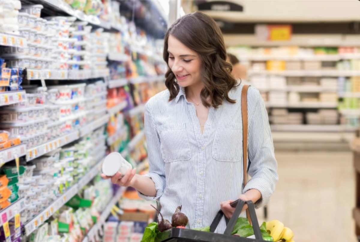 Donna guarda lo yogurt al supermercato