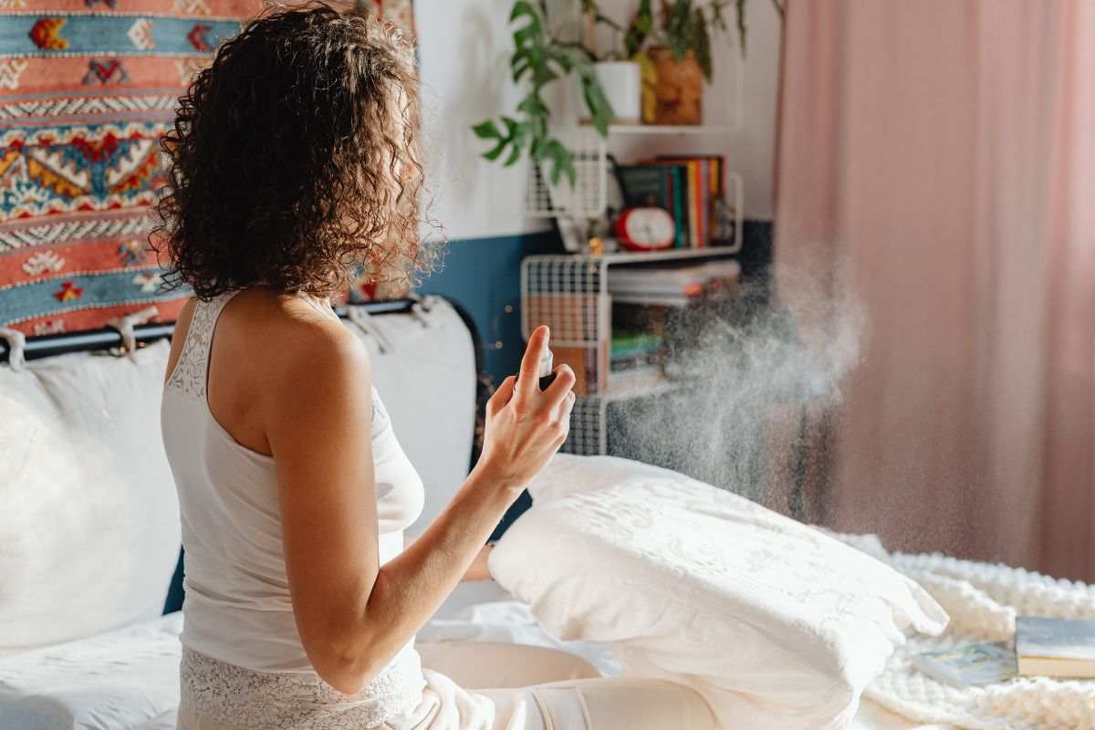 Donna vaporizza profumo in casa