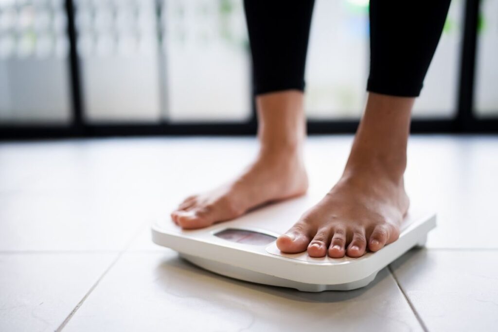 Persona si pesa sulla bilancia