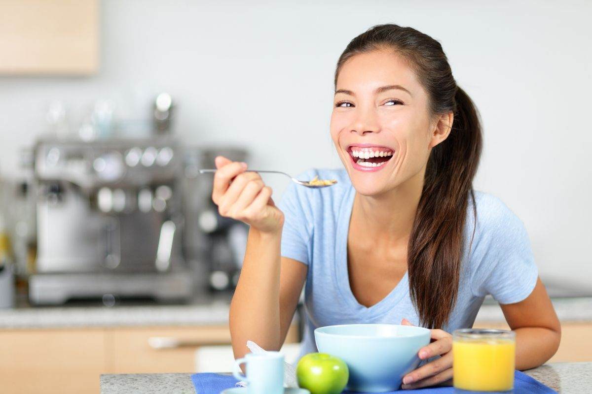 Ragazza sorridente fa colazione a casa