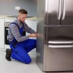 Un tecnico che ripara un frigorifero che non funziona