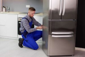 Un tecnico che ripara un frigorifero che non funziona