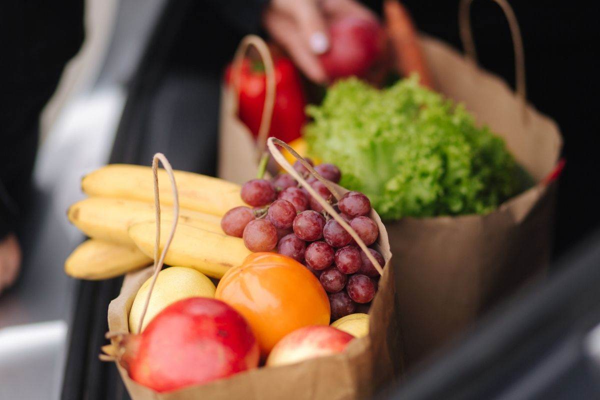 Buste della spesa contenenti frutta e verdura