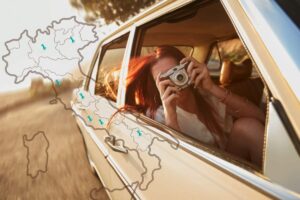 ragazza che scatta foto in macchina con cartina Italia