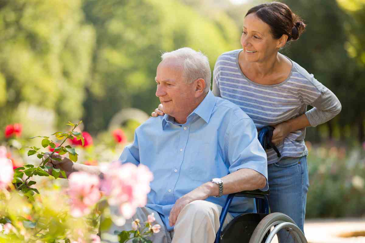 una donna spinge anziano sulla sedia a rotelle
