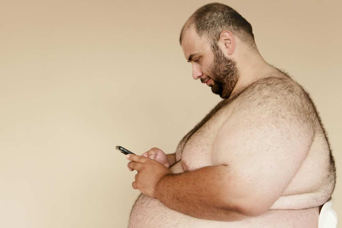 persona obesa col cellulare in mano