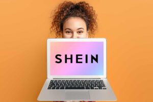 donna mostra computer con logo di shein sulla schermata