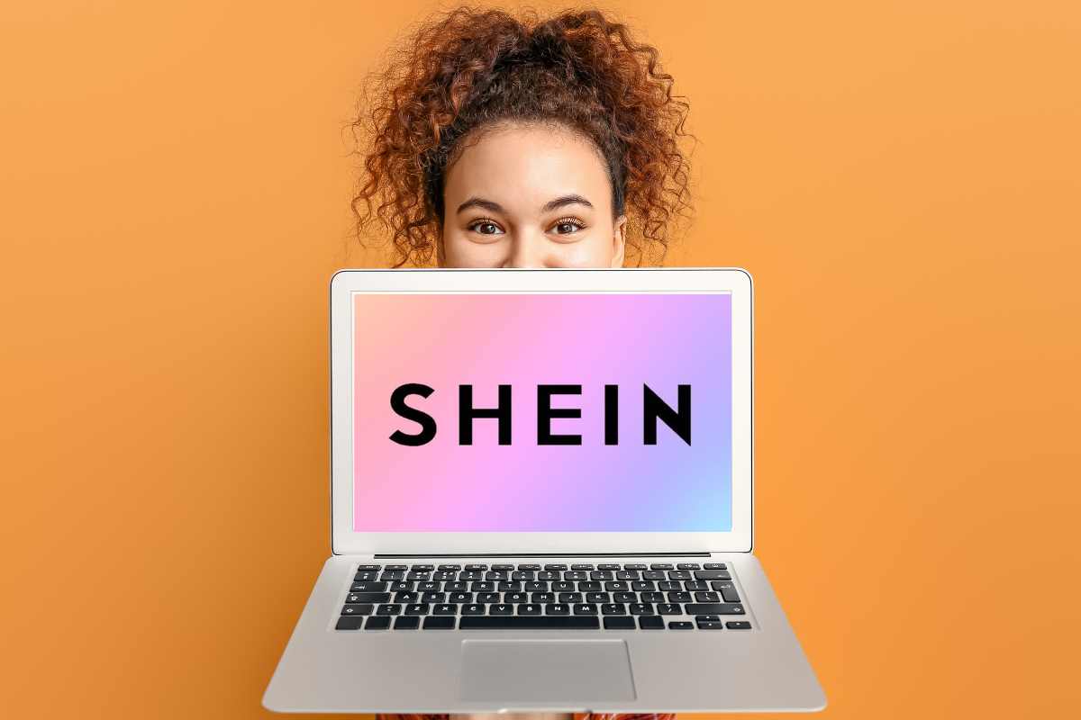 donna mostra computer con logo di shein sulla schermata