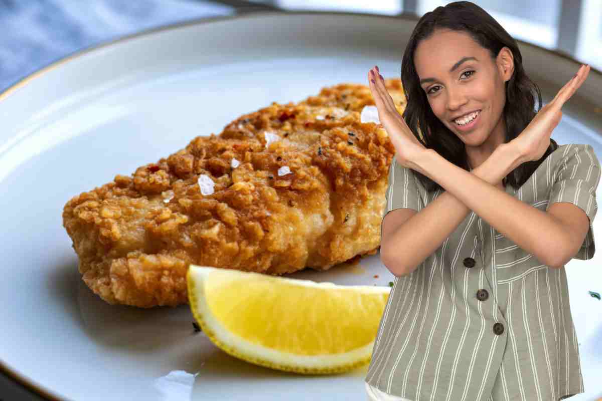 una donna mostra una x davanti a un merluzzo fritto