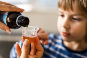 bambino che prende sciroppo per la tosse