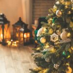 albero natale su parquet e lanterne decorative accese