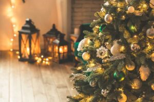 albero natale su parquet e lanterne decorative accese
