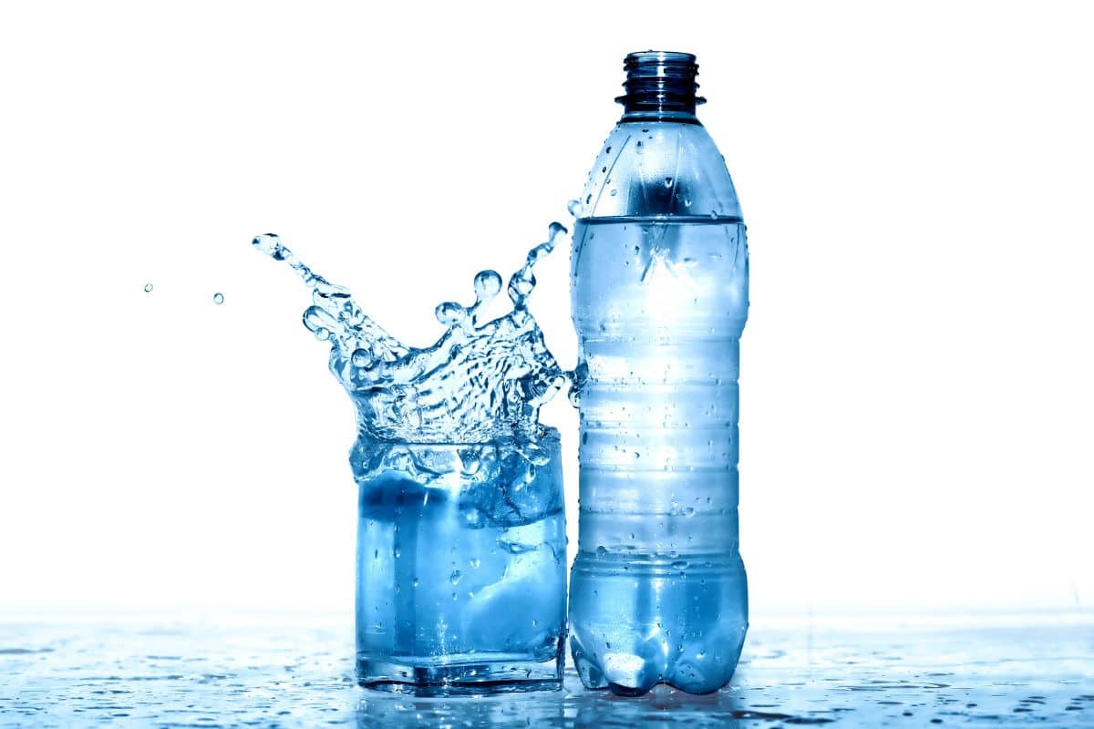 bicchiere d'acqua con bottiglia d'acqua plastica senza tappo