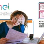 sullo sfondo una bolletta fac simile enel e in primo piano una donna che legge una bolletta preoccupata