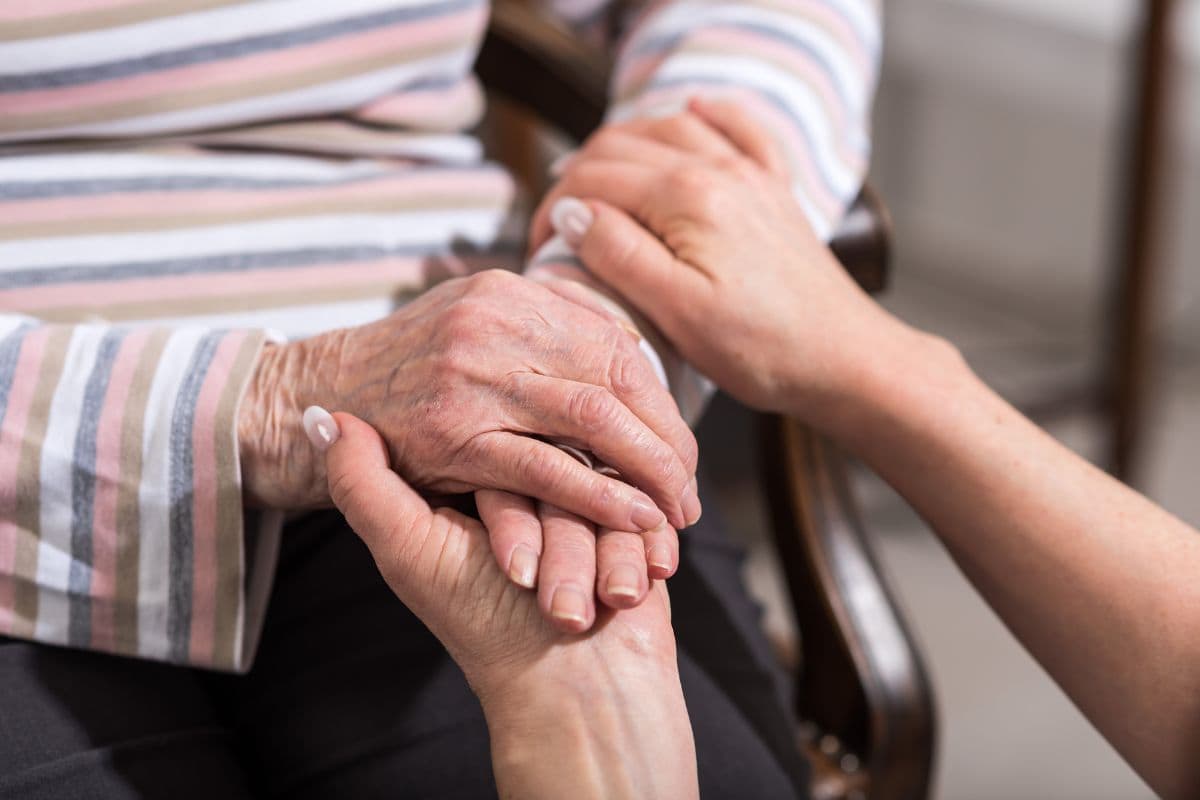 mani di donna giovane che stringono mani di donna anziana