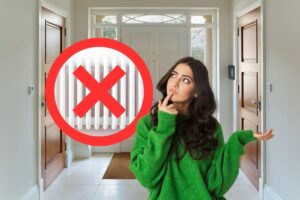entrata di casa con termosifoni con x rossa sopra e donna pensierosa