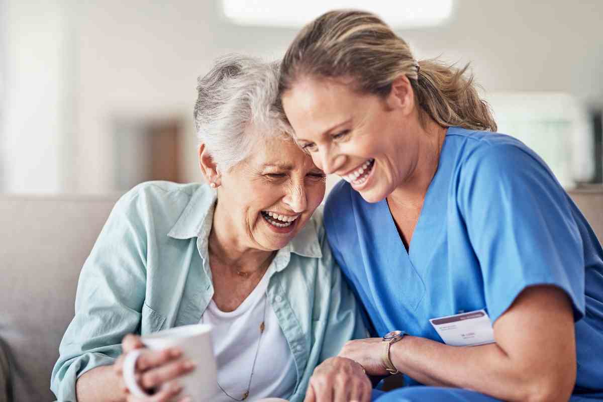 donna anziana con caregiver sorridono