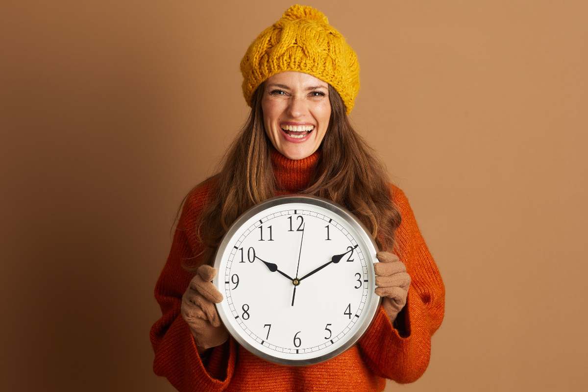 donna vestita autunnale con orologio in mano
