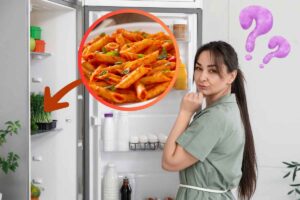 donna pensa vicino al frigo pasta freccia e punti interrogativi