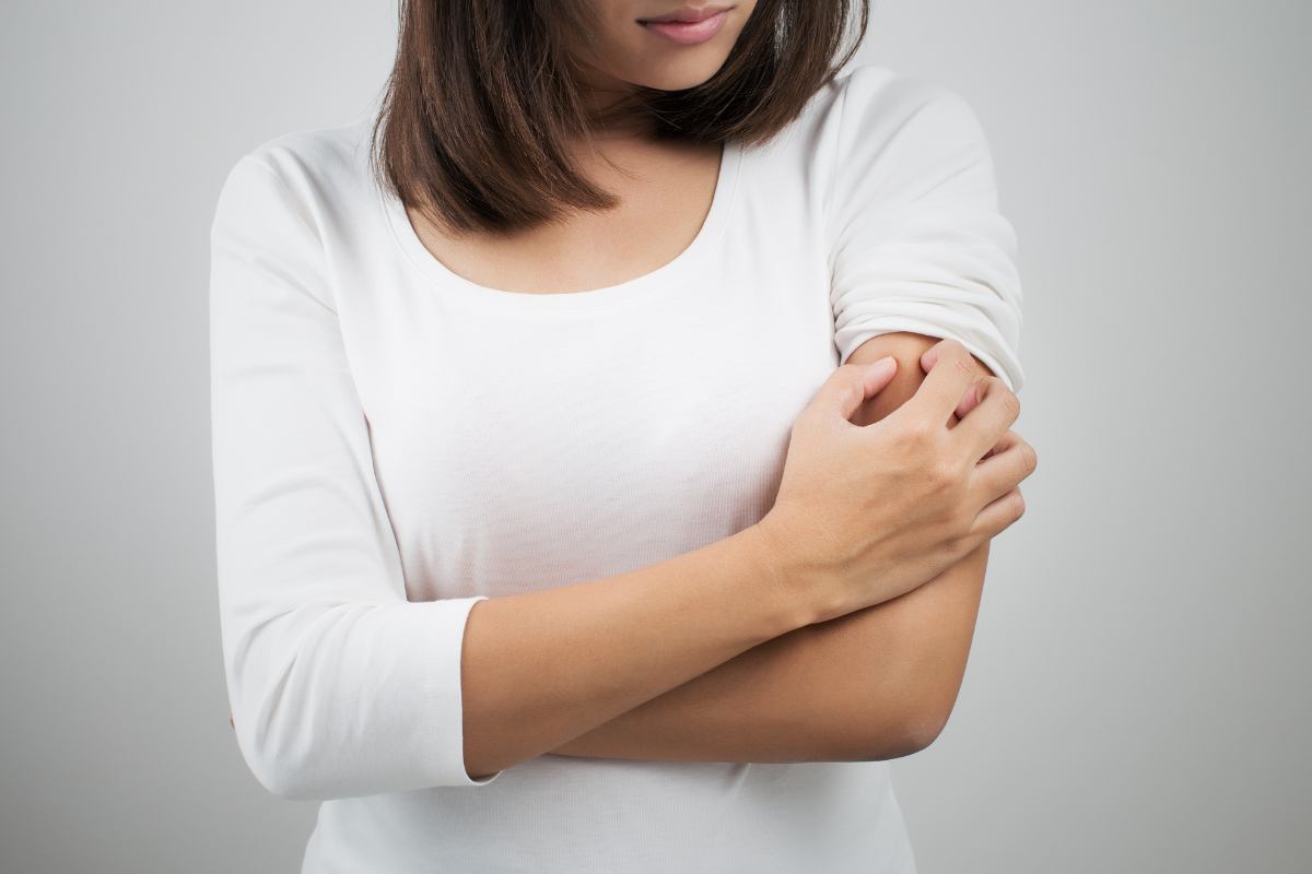 donna si gratta il braccio
