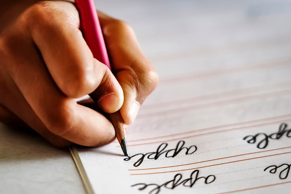 bambino scrive in corsivo