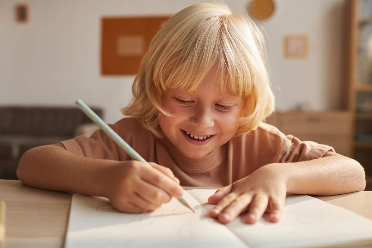 bambino felice scrive su foglio