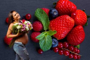 donna incinta e frutti rossi