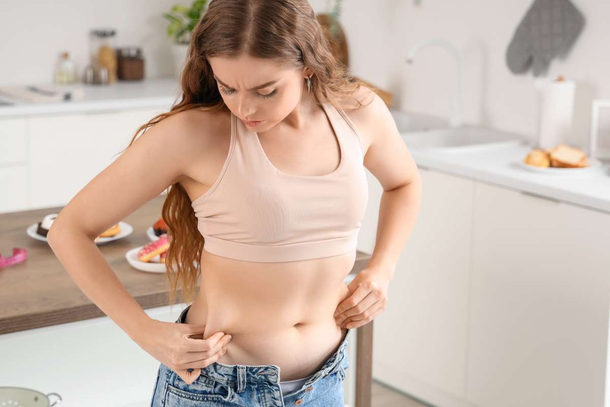 ragazza si tocca la pancia