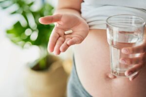 donna in gravidanza prende vitamina e acqua