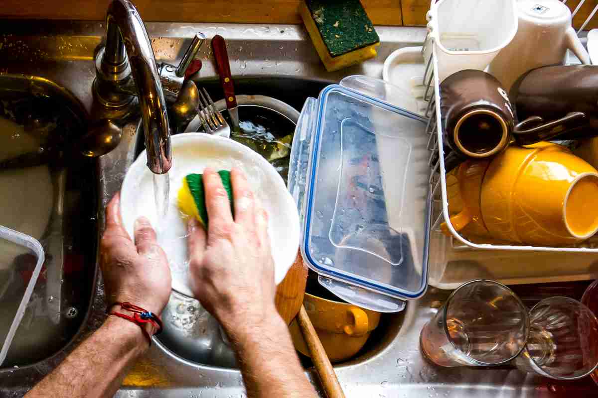 persona lava i piatti a mano